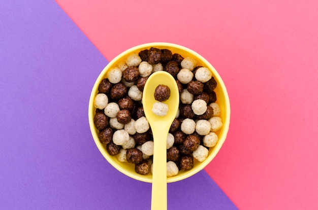 Foto gratuita cucchiaio giallo vista dall'alto con ciotola di cereali al cioccolato