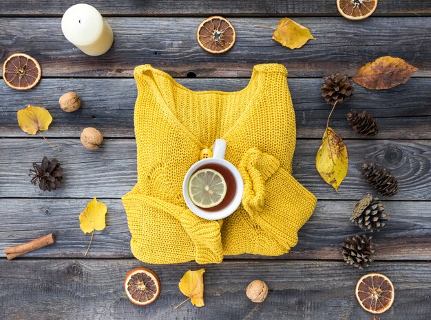 Top view yellow sweater on wooden background