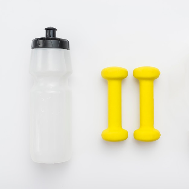 Top view of yellow weights and water bottle