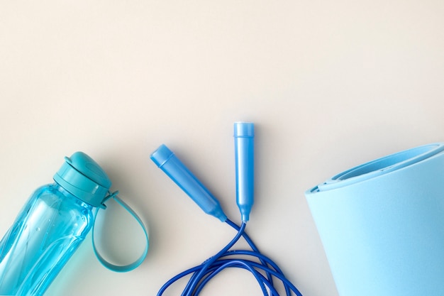 Top view yoga mat, water bottle and jumping rope