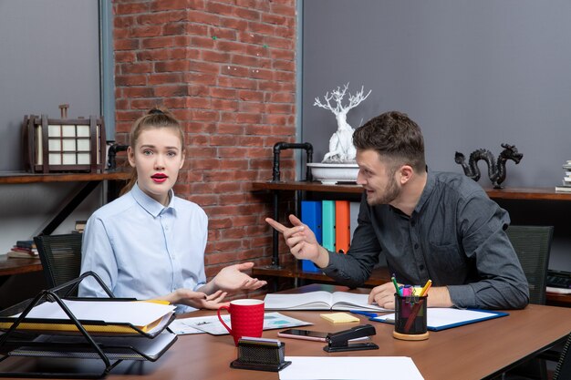 Top view of young busy office team sitting at the table discussing one important issue in the office