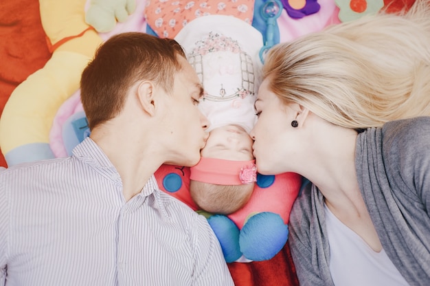 Top view of young couple kissing their baby