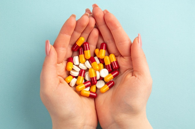 top view young female with pills in her hands on blue background pandemic covid- virus health lab science hospital color