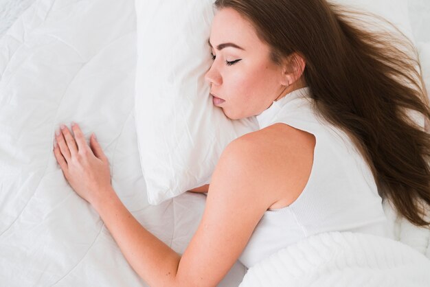 Top view young girl sleeping in bed