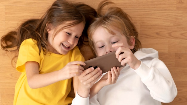 Top view of young kids using smartphone together