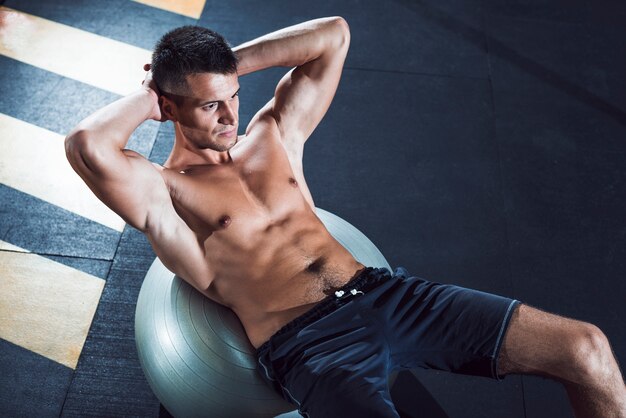 Top view of young man exercising on exercise ball