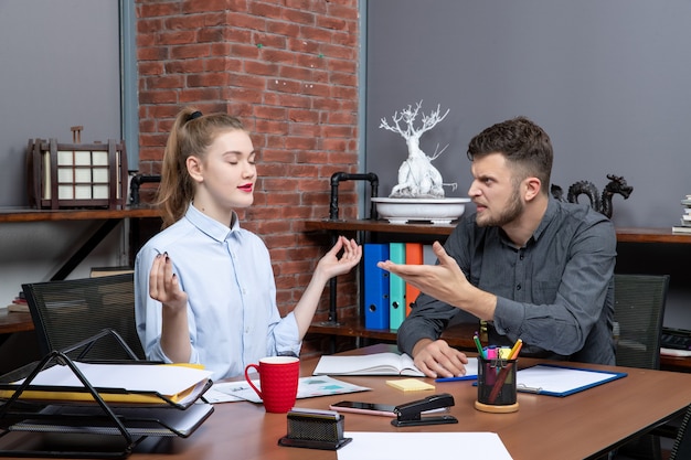 Free photo top view of young man is angry with his female co-worker in office enviroment