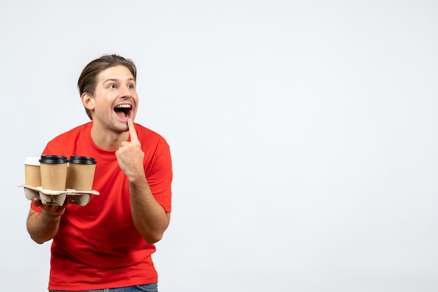 Top view of young man in red blouse holding orders making smile gesture on white background