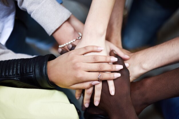 Top view of young people putting their hands together.