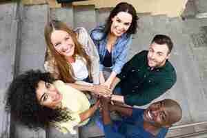 Free photo top view of young people putting their hands together.