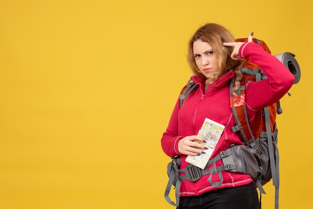 Top view of young travelling girl in medical mask collecting her luggage and holding map in deep thoughts