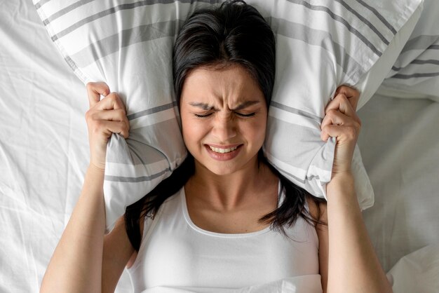 Top view young woman holding pillow in bed