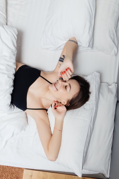 Top view of Young woman lying in bed doesn't want to wake up