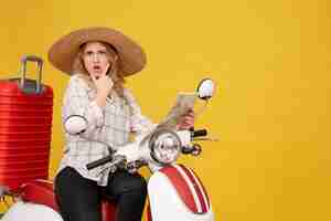 Free photo top view of young woman wearing hat and sitting on motorcycle and holding map with confused facial epression on yellow