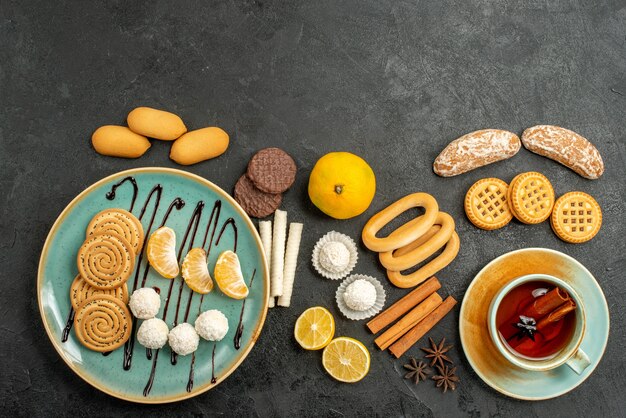 Top view yummy biscuits with cup of tea on grey background