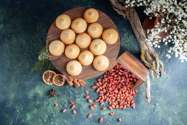 Вид сверху вкусное печенье с арахисом на темно-синем фоне печенье бисквит сладкий торт пирог сахарных цветов