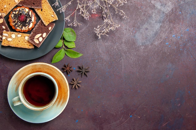 Free photo top view of yummy cake slices with cup of tea on black