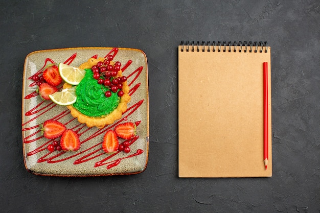 어두운 배경 디저트 달콤한 차에 녹색 크림과 딸기와 상위 뷰 맛있는 케이크