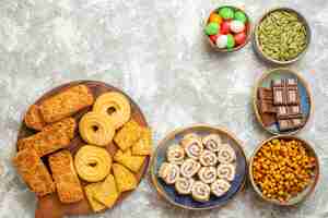 Free photo top view yummy cakes with candies and cookies on white background