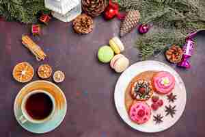 Free photo top view of yummy cakes with french macarons and tea on black