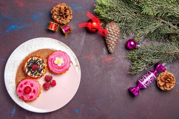 Top view of yummy cakes with fruits and cream on black