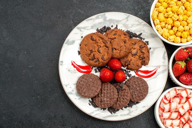 Top view yummy choco biscuits with candies on a dark background sugar cake sweet cookie