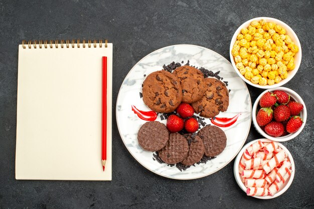 Top view yummy choco biscuits with candies on dark background sugar cake sweet cookies