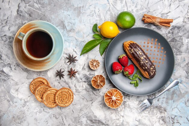 軽いデザートケーキビスケットにフルーツと紅茶を添えたトップビューのおいしいチョコエクレア
