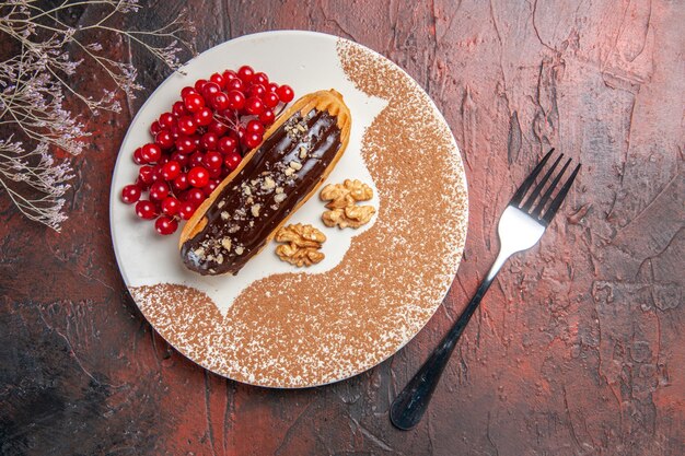 어두운 테이블 케이크 파이 디저트 달콤한에 빨간 열매와 상위 뷰 맛있는 초코 eclairs