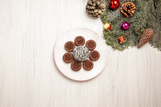 Free photo top view yummy chocolate cookies with little cocoa cake on a white