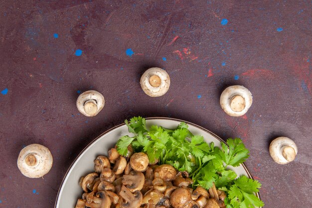 Free photo top view yummy cooked mushrooms with greens on a dark