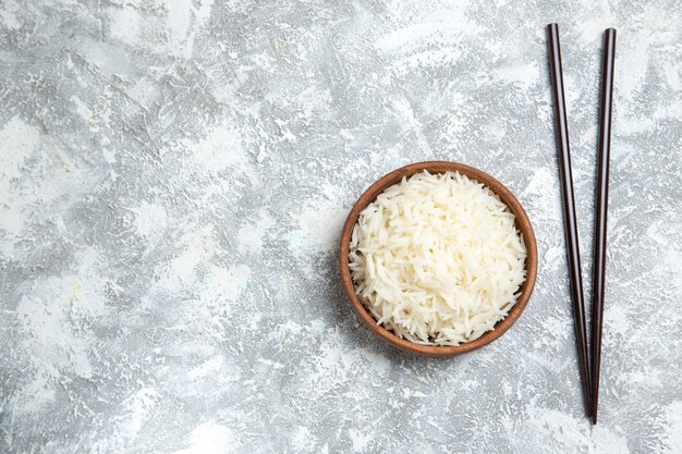 Top view yummy cooked rice inside brown plate on a white