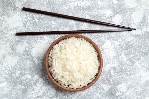 Vista dall'alto gustoso riso cotto all'interno del piatto marrone su bianco