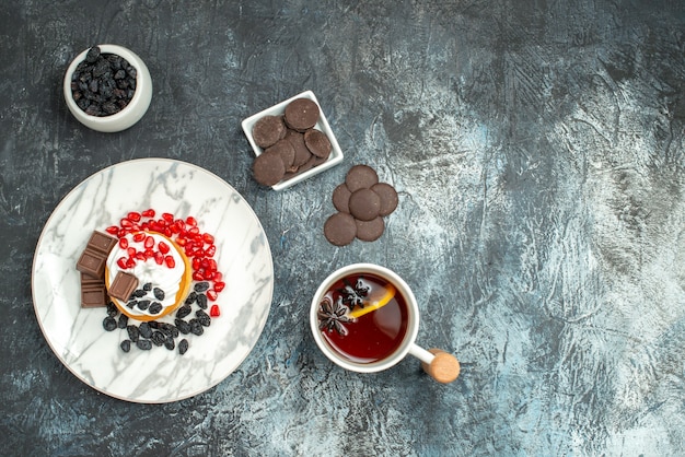 明暗の背景にチョコビスケットとお茶のトップビューおいしいクリーミーなケーキ