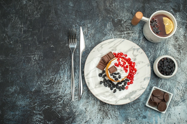 Torta cremosa gustosa vista dall'alto con una tazza di tè su sfondo chiaro-scuro