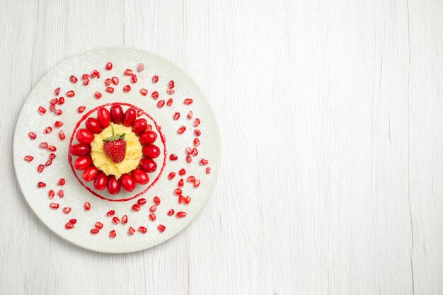 Top view yummy creamy cake with dogwoods on the white desk