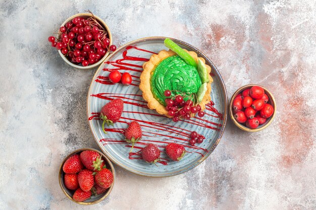 Top view yummy creamy cake with fresh fruits on light floor biscuit dessert cake sweet