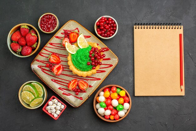 Top view yummy creamy cake with fruits on dark background biscuit dessert sweet