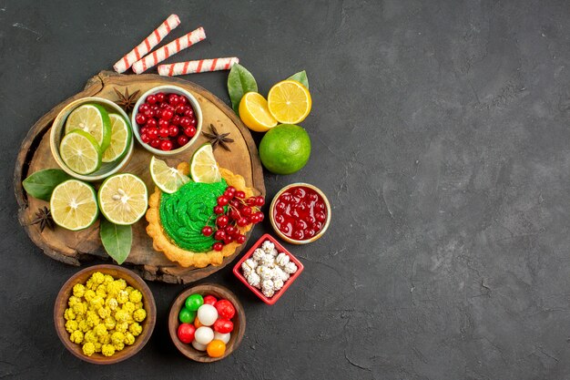 Top view yummy creamy cake with fruits on dark background sweet biscuit cookie free place