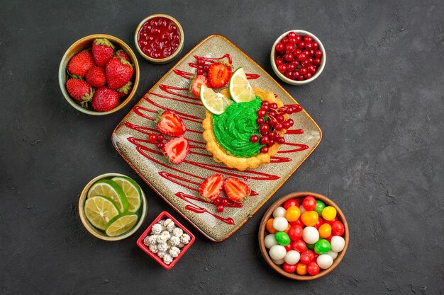 Top view yummy creamy cake with strawberries on the dark background sweet sugar dessert tea