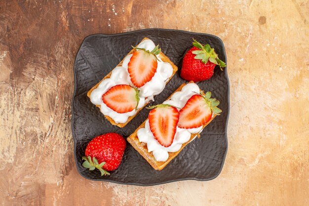 Top view yummy creamy cakes with fruits on light background