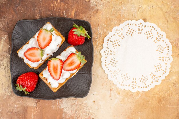 Top view yummy creamy cakes with fruits on light background