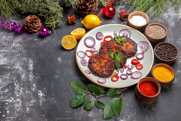 회색 배경 접시 고기 식사에 양파 링 상위 뷰 맛있는 커틀릿 photo
