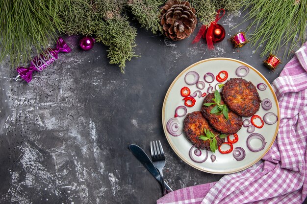 Вид сверху вкусные котлеты с луковыми кольцами на сером полу, мясное блюдо, еда, фото