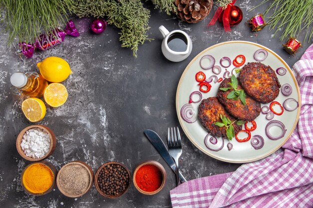 Вид сверху вкусные котлеты с луковыми кольцами на светло-сером фоне фото обеда мясное блюдо