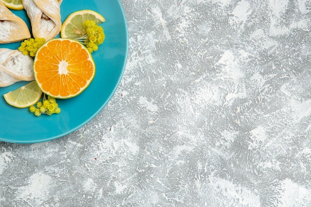 Vista dall'alto deliziose paste di pasta con fette di limone su una superficie bianca chiara