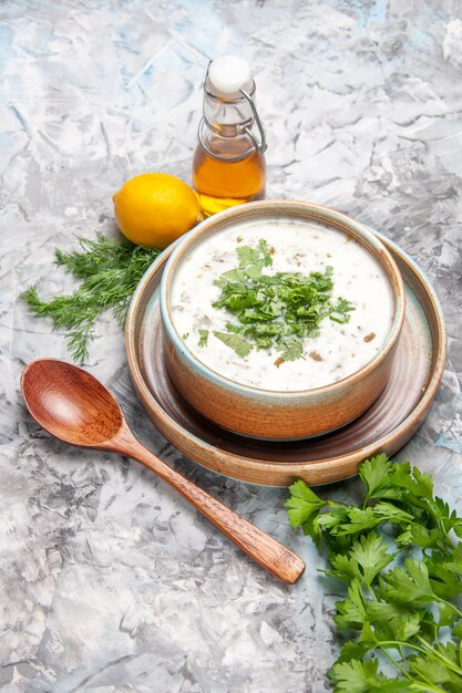 Вид сверху вкусный йогуртовый суп Довга с зеленью на белом суповом блюде молочные продукты