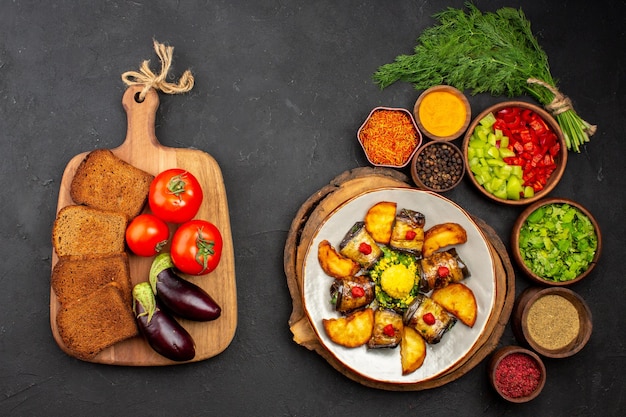 Vista dall'alto involtini di melanzane gustosi piatti cucinati con patate e condimenti sulla superficie scura pasto per piatti cena cibo