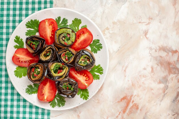 Top view yummy eggplant rolls with tomatoes and greens