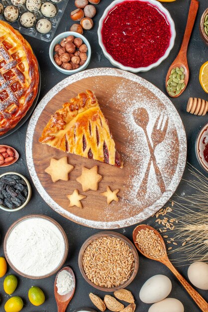 Top view yummy fruit pie with jam nuts and flour on the dark biscuit dessert pie tea cake dough sweet bake sugar